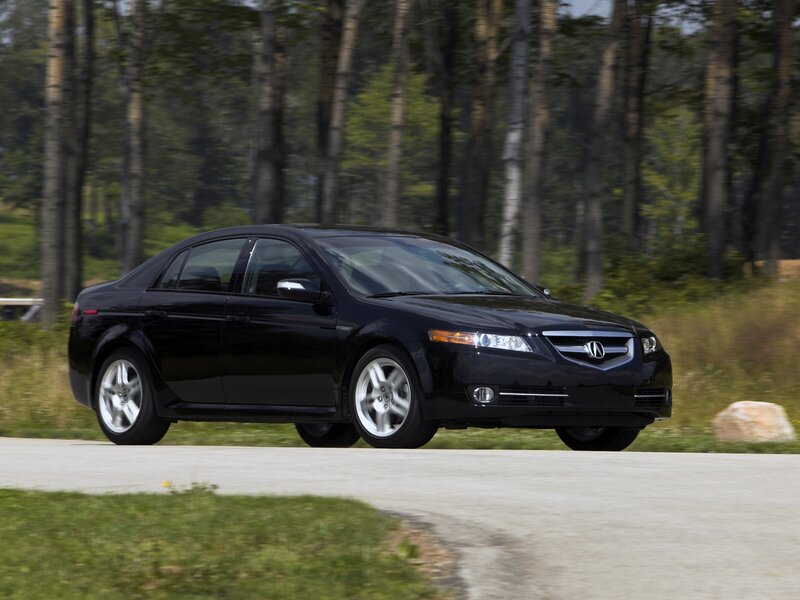 Black Acura TL on a forest road