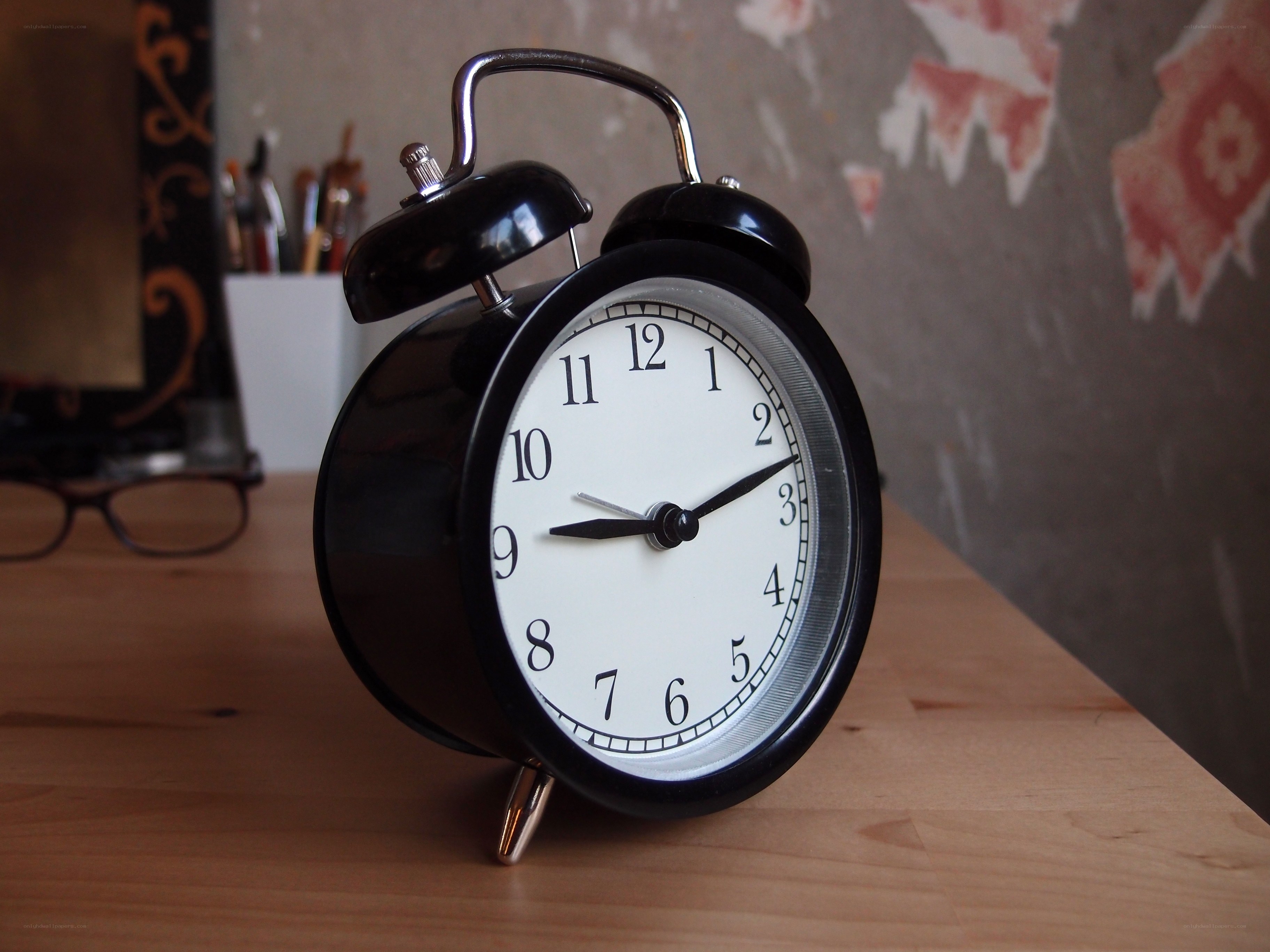 Black alarm clock on wooden table