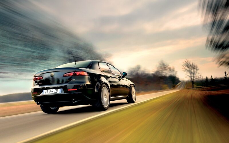 Black Alfa Romeo driving on road