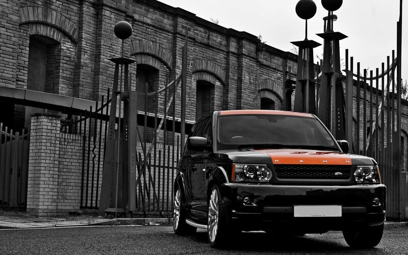 Black and Orange SUV — Dramatic, Photograph, Brick Building