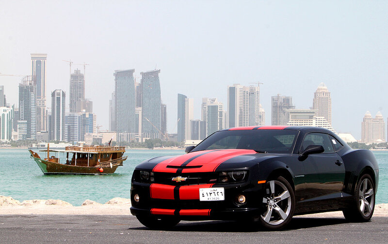 Black and red Camaro by the water
