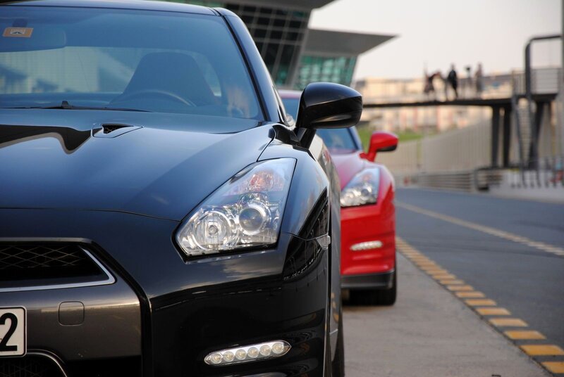 Black and red sports cars on a road