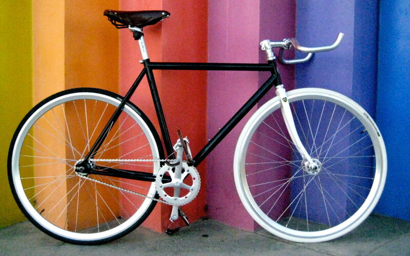 black and white bicycle against colorful wall