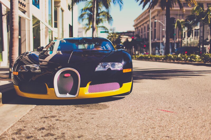 Black and Yellow Bugatti — Sunny, Afternoon, Photograph, Car, Palm Trees, Building
