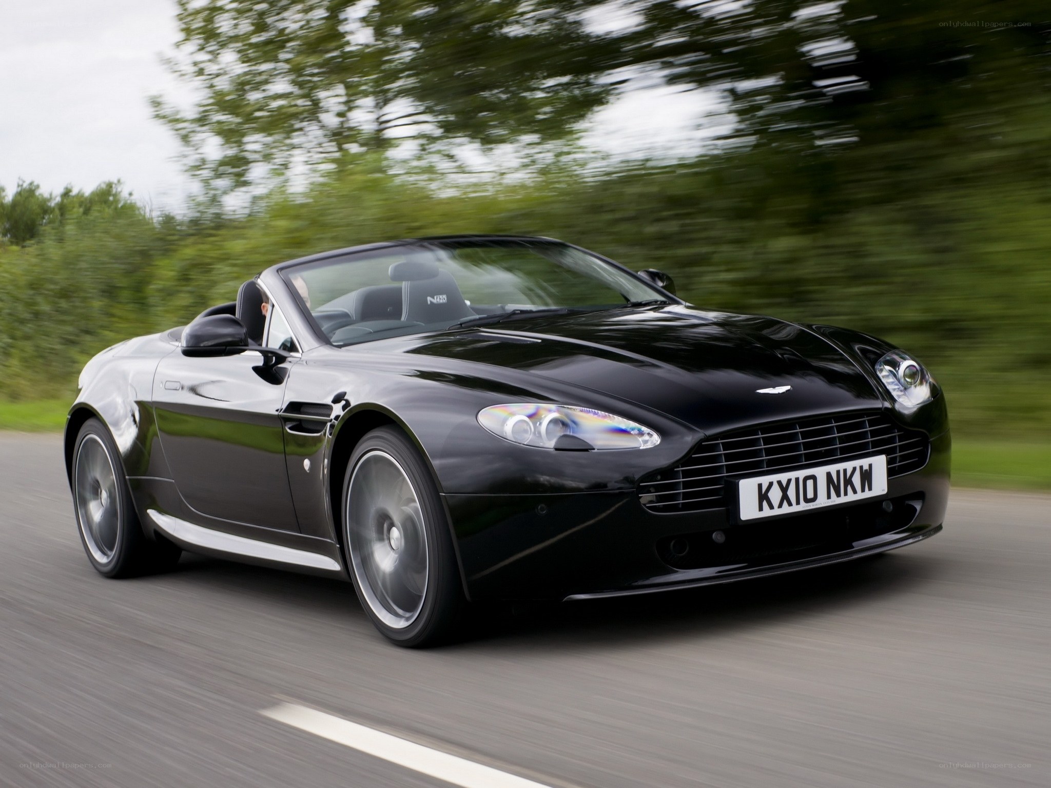 Black Aston Martin convertible in motion