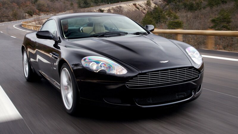 black aston martin driving on road