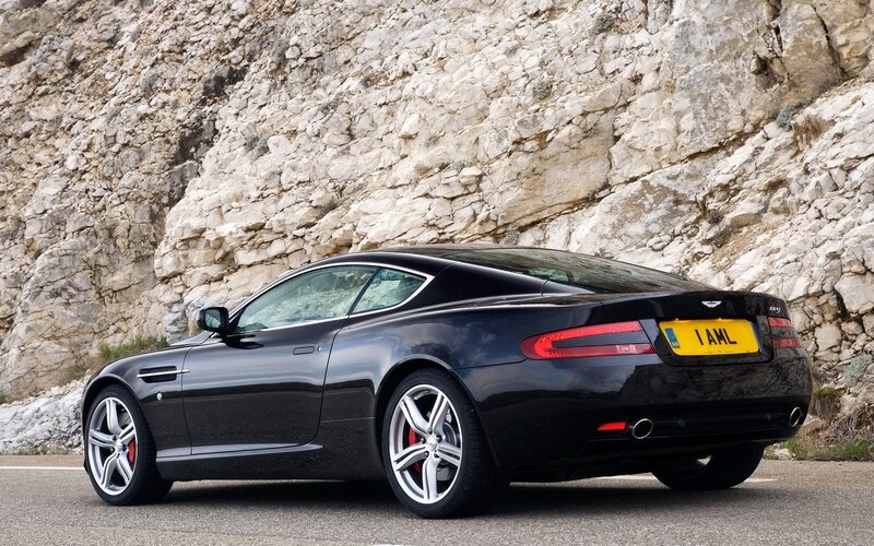 Black Aston Martin on a mountain road
