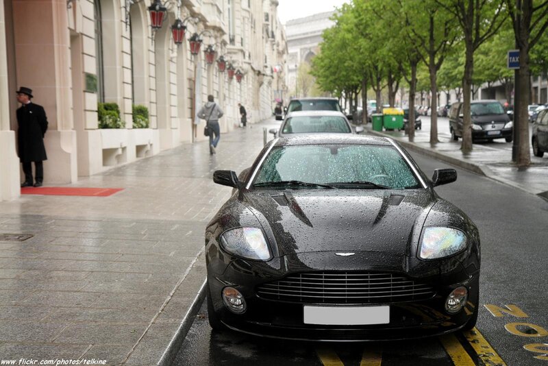 Black Aston Martin on a rainy Paris street