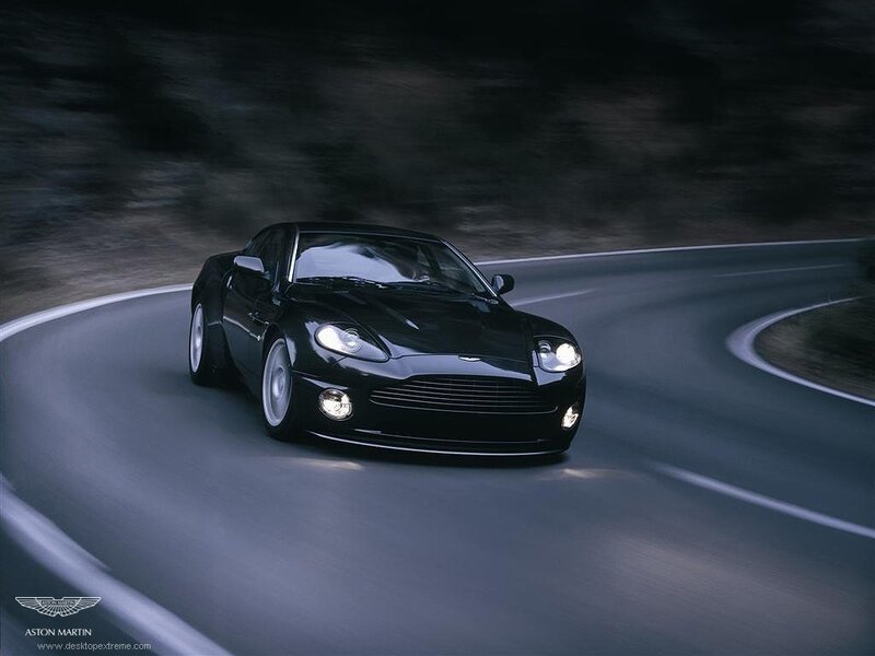 Black Aston Martin on a winding road