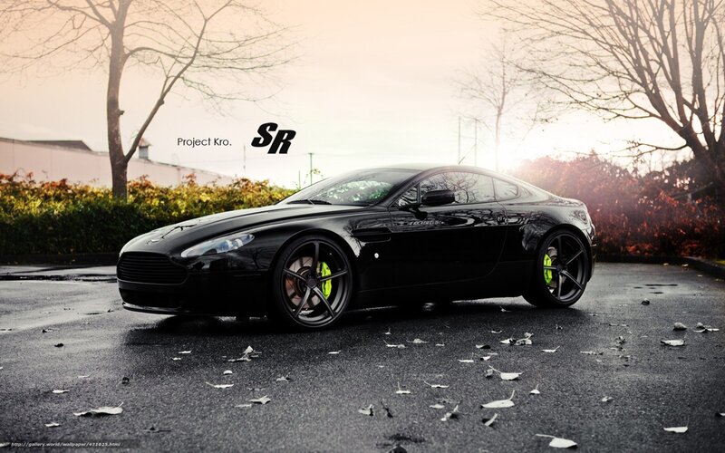 Black Aston Martin on wet pavement
