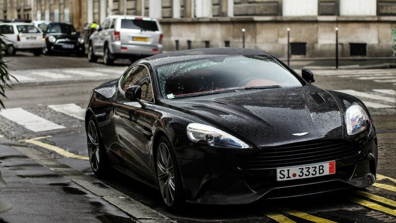 black aston martin on wet street