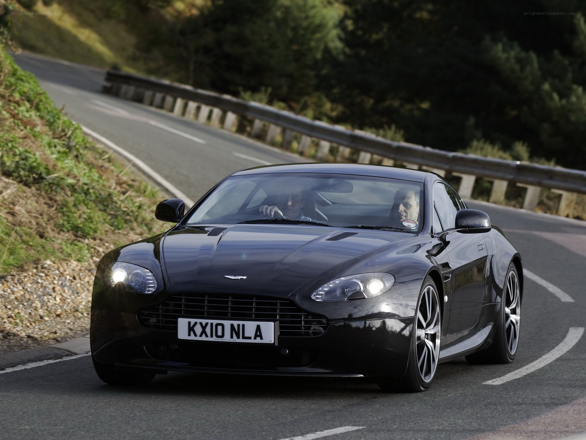 Black Aston Martin on winding road
