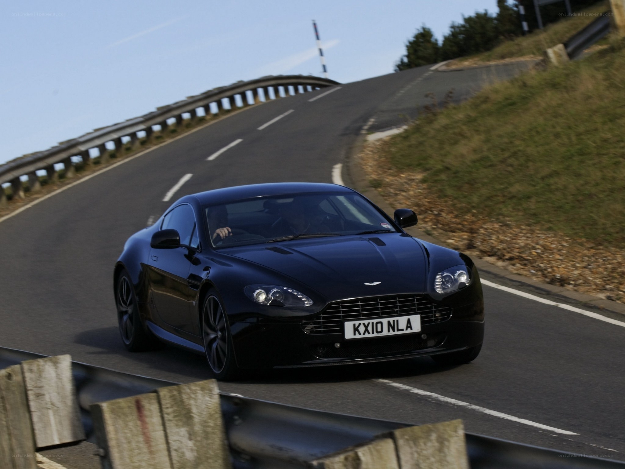 Black Aston Martin on winding road