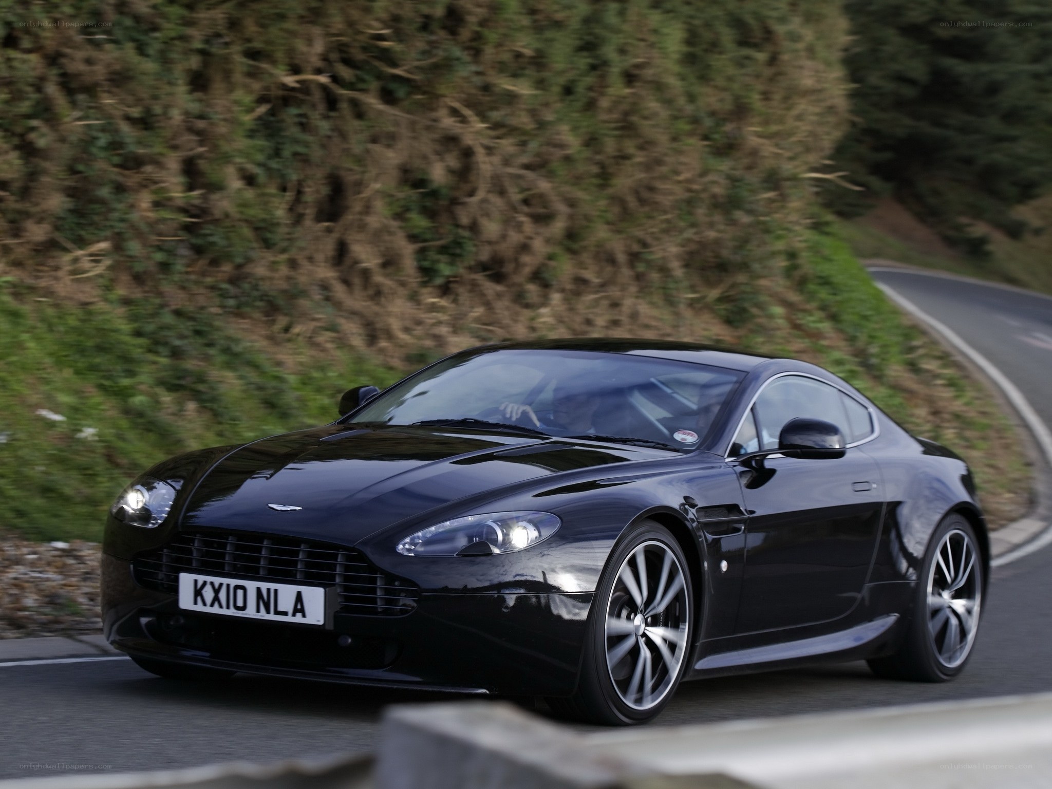 Black Aston Martin on winding road