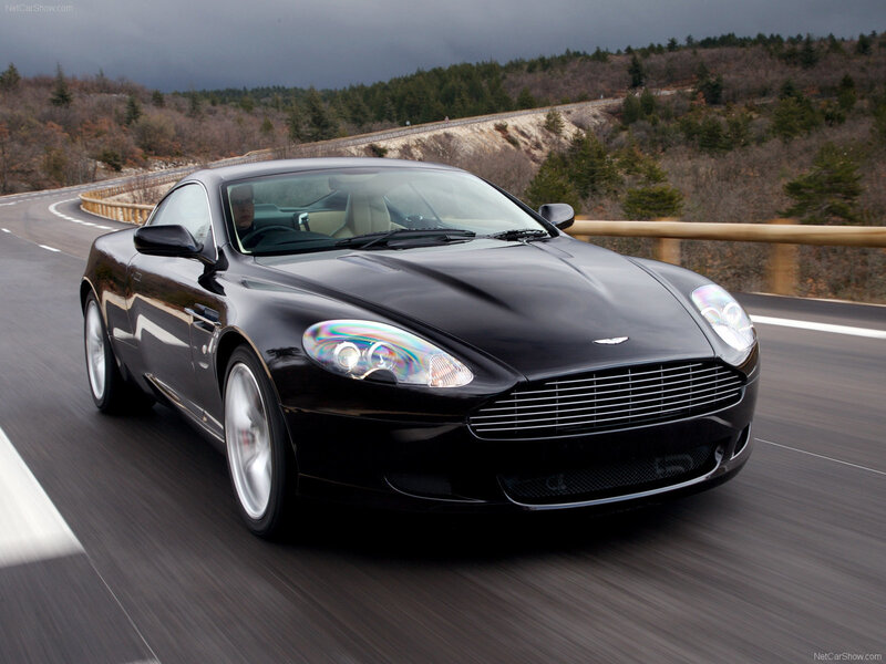 black aston martin on winding road