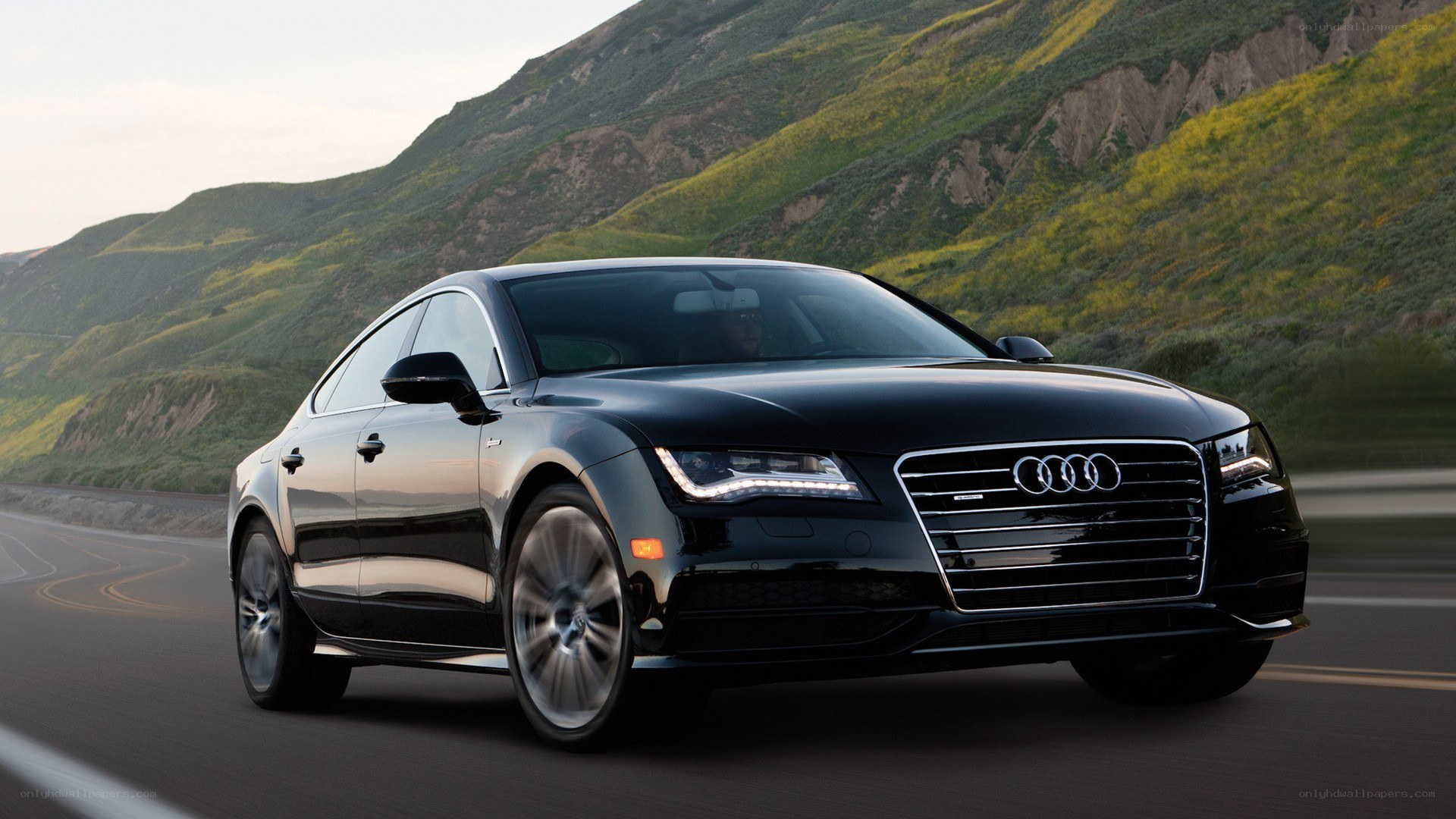 Black Audi driving on mountain road