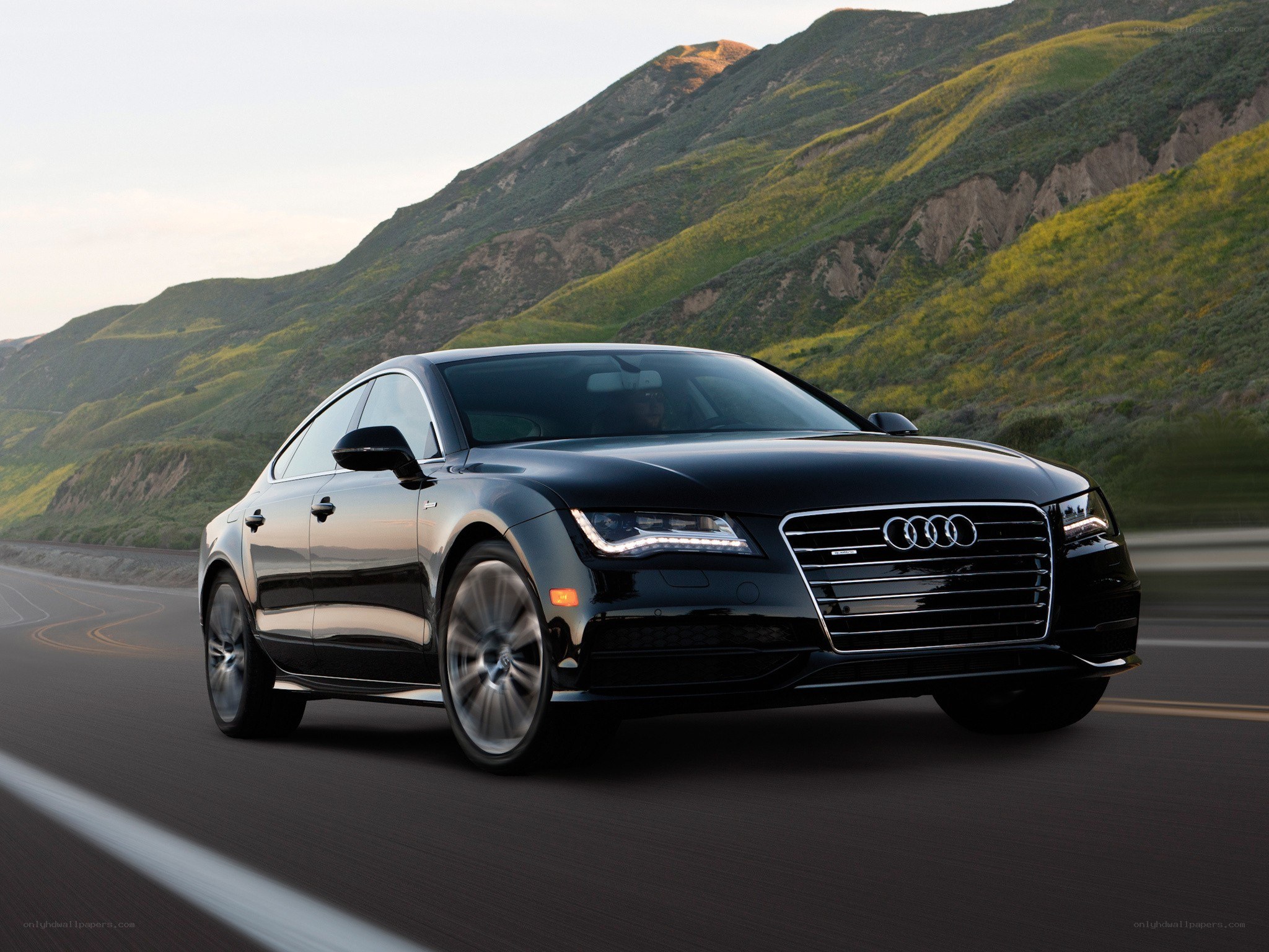 Black Audi driving on mountain road