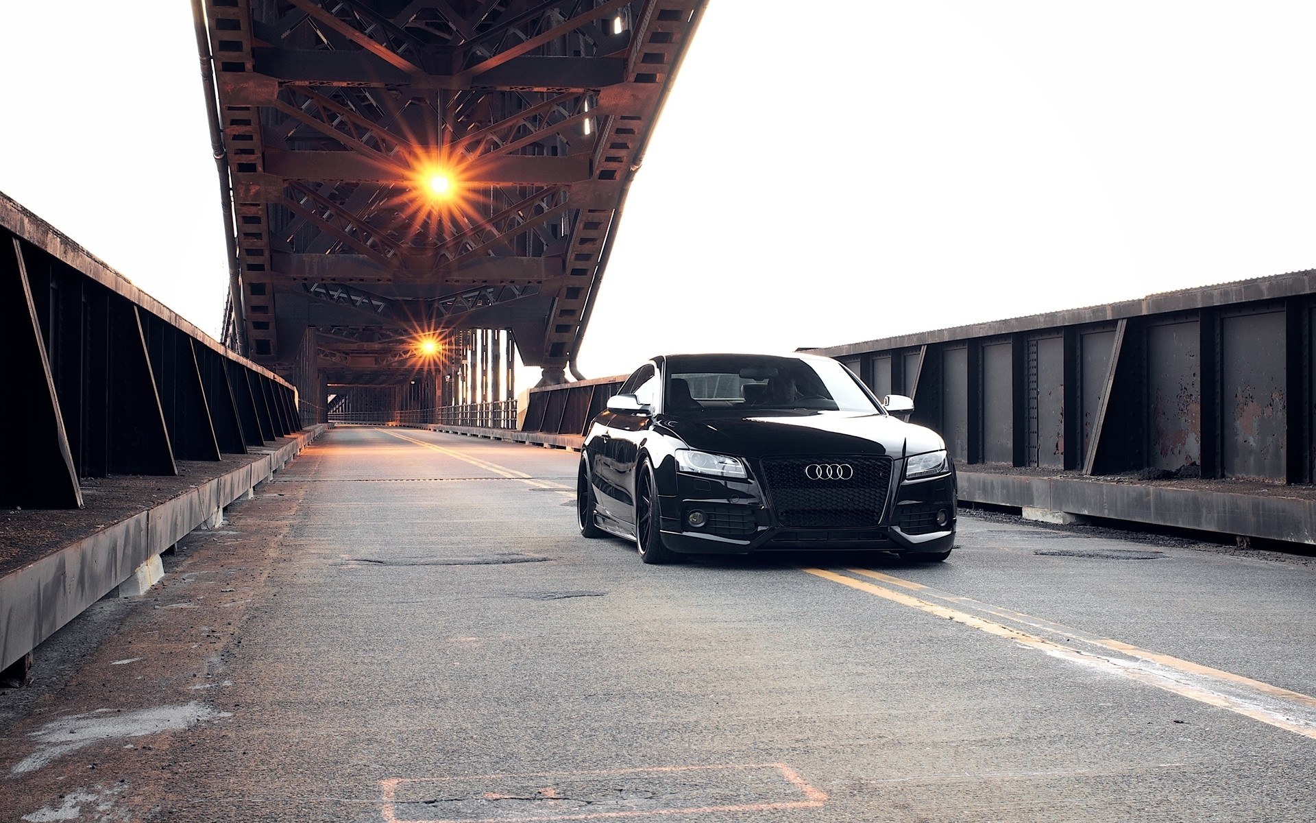 Black Audi on a bridge at sunset