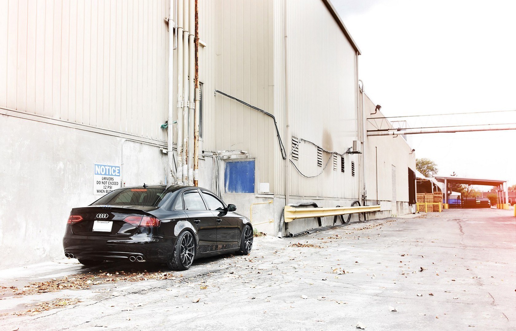 Black Audi parked by warehouse
