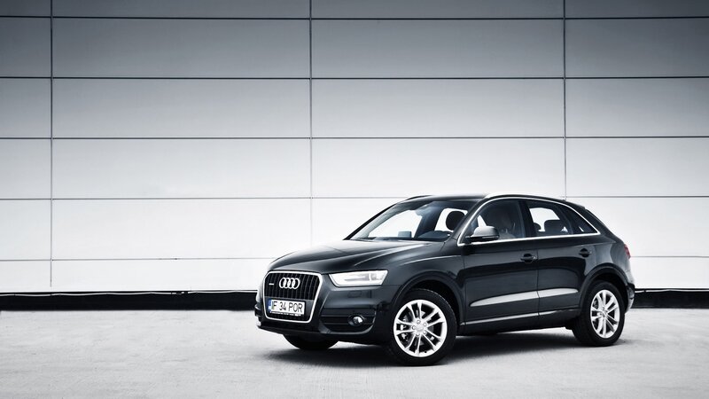 Black Audi Q3 parked in front of wall