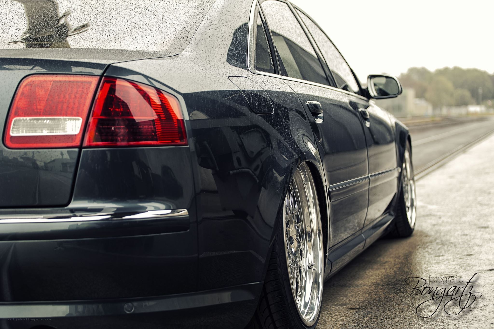 black audi sedan on wet road