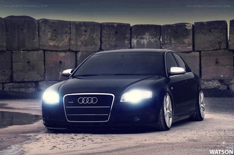 Black Audi sedan with headlights on