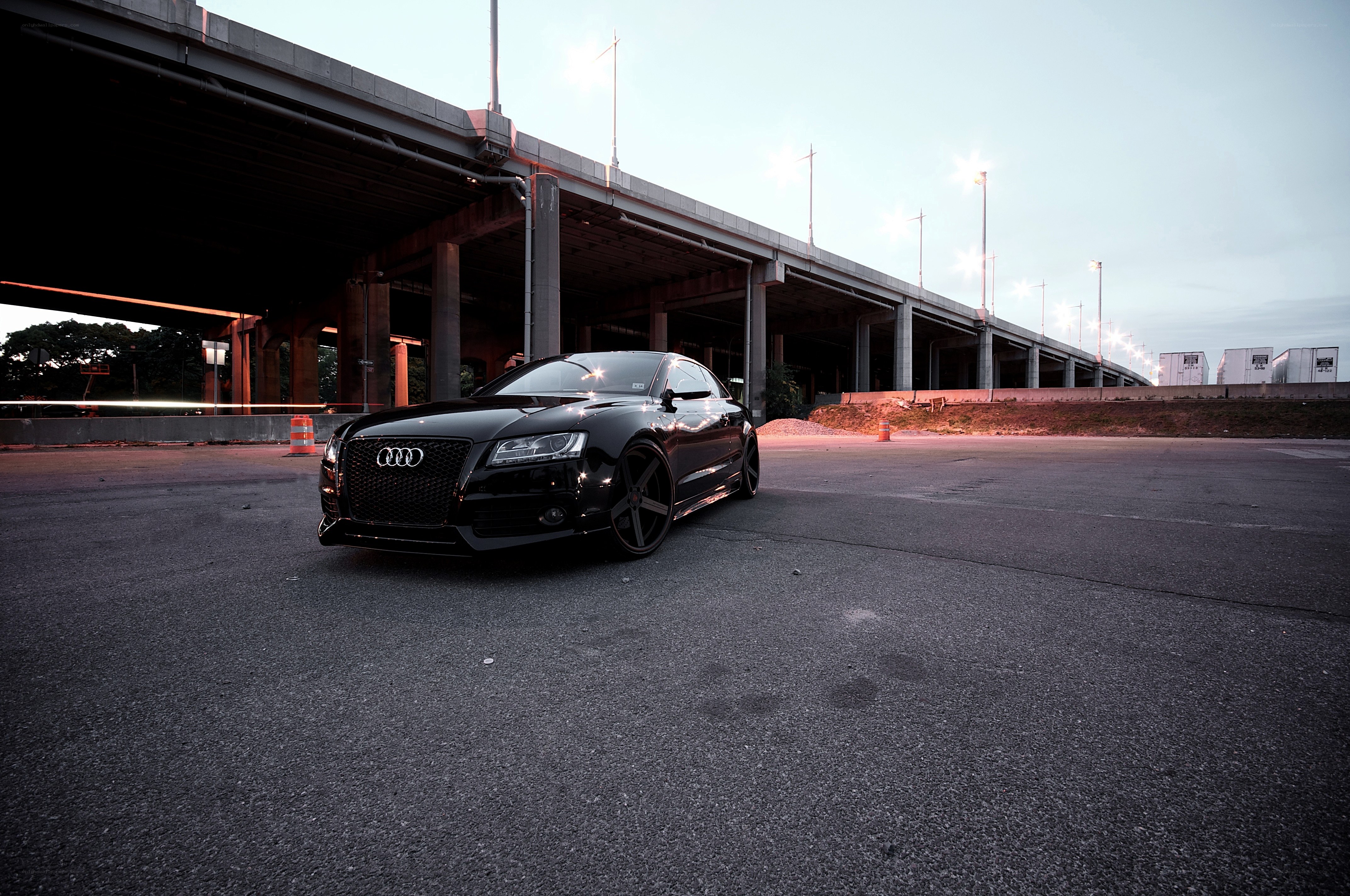 Black Audi under highway overpass