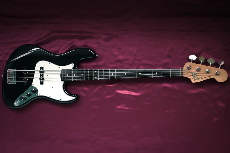 black bass guitar on purple cloth