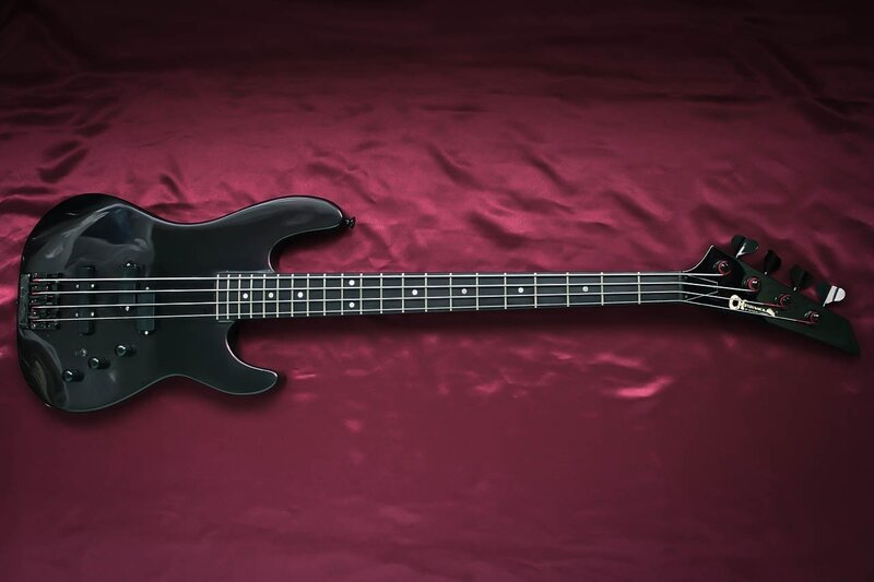 black bass guitar on red fabric