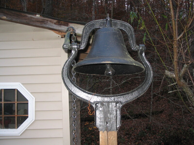 Black Bell on Wooden Post