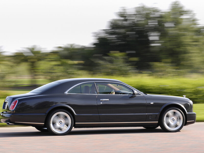 black bentley driving on road