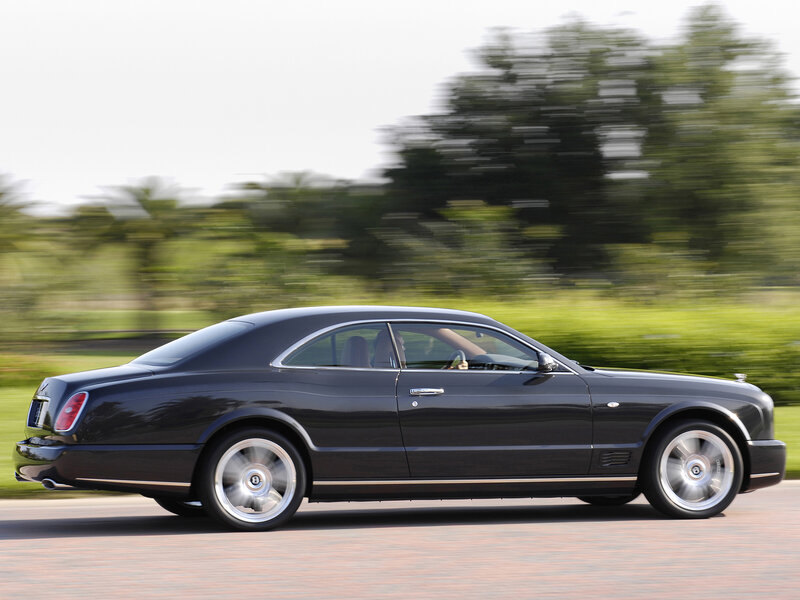 Black Bentley driving on road