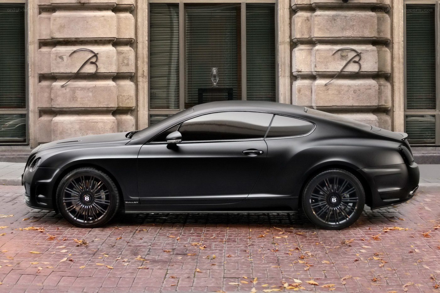 Black Bentley parked on cobblestones