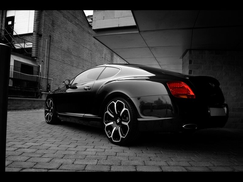 Black Bentley parked on cobblestones