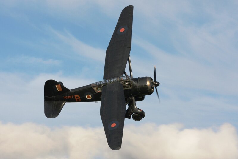 Black biplane in flight