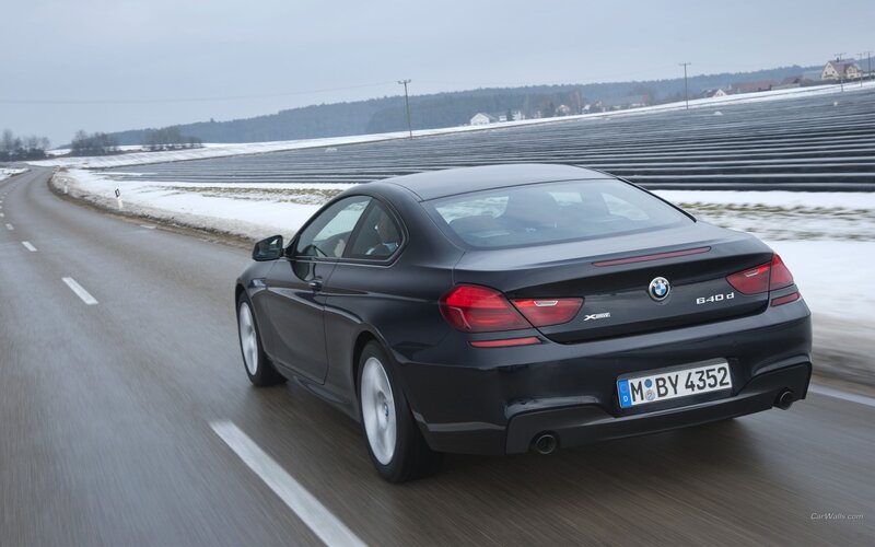 Black BMW 640d driving on road