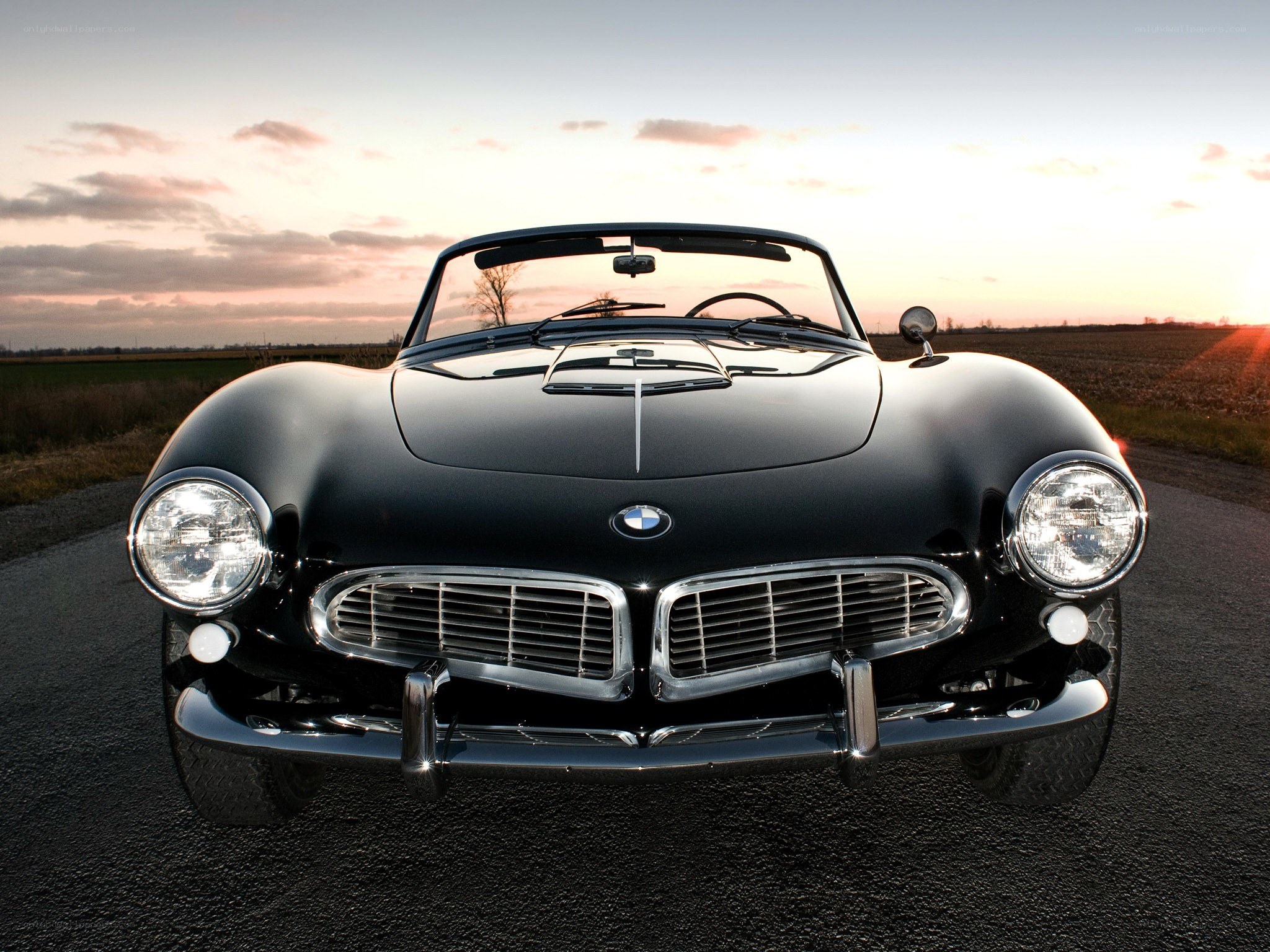 Black BMW convertible at sunset
