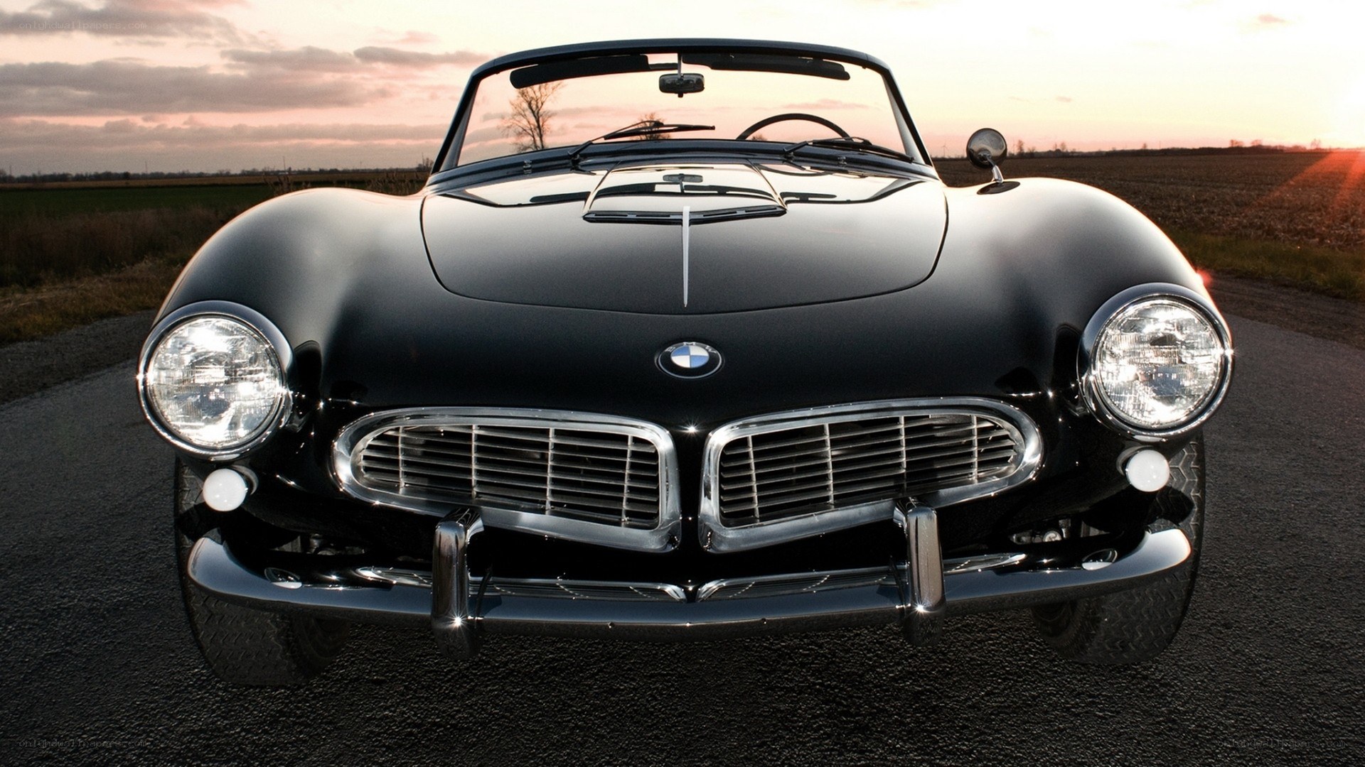Black BMW convertible at sunset