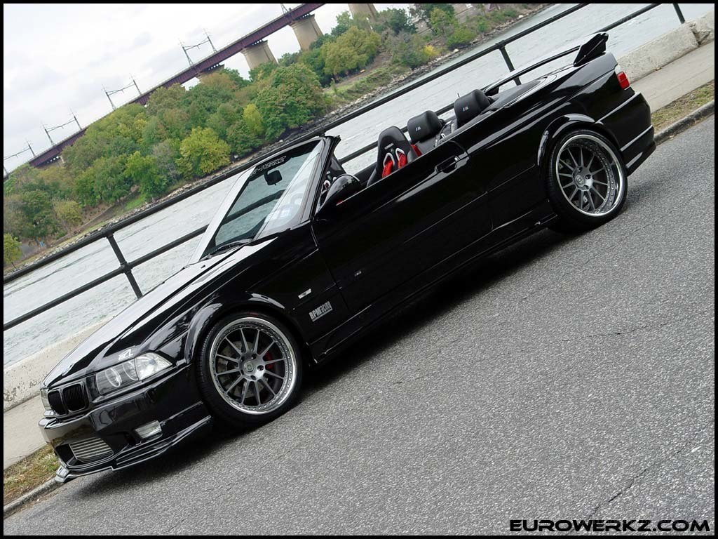 black bmw convertible by water