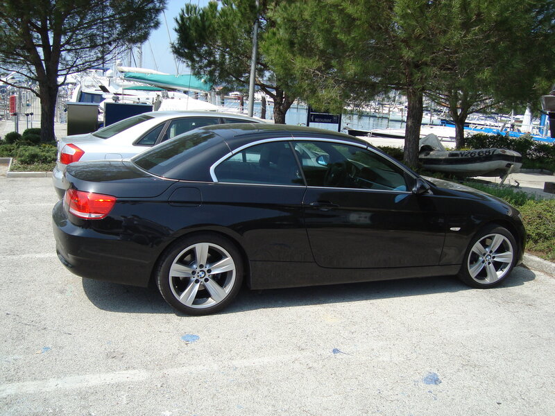 Black BMW convertible parked near marina