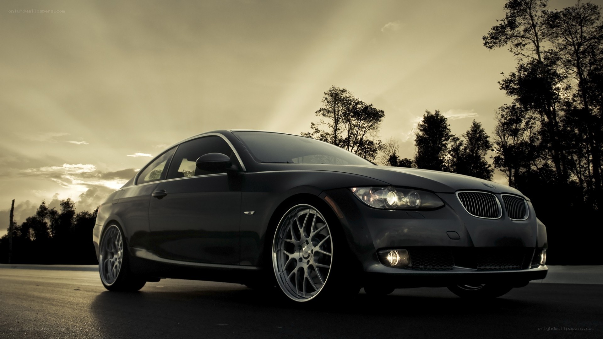 black bmw coupe at sunset