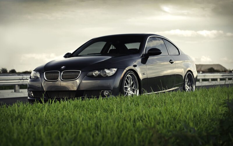 Black BMW coupe on grass