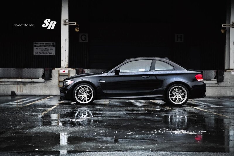 Black BMW coupe on wet pavement