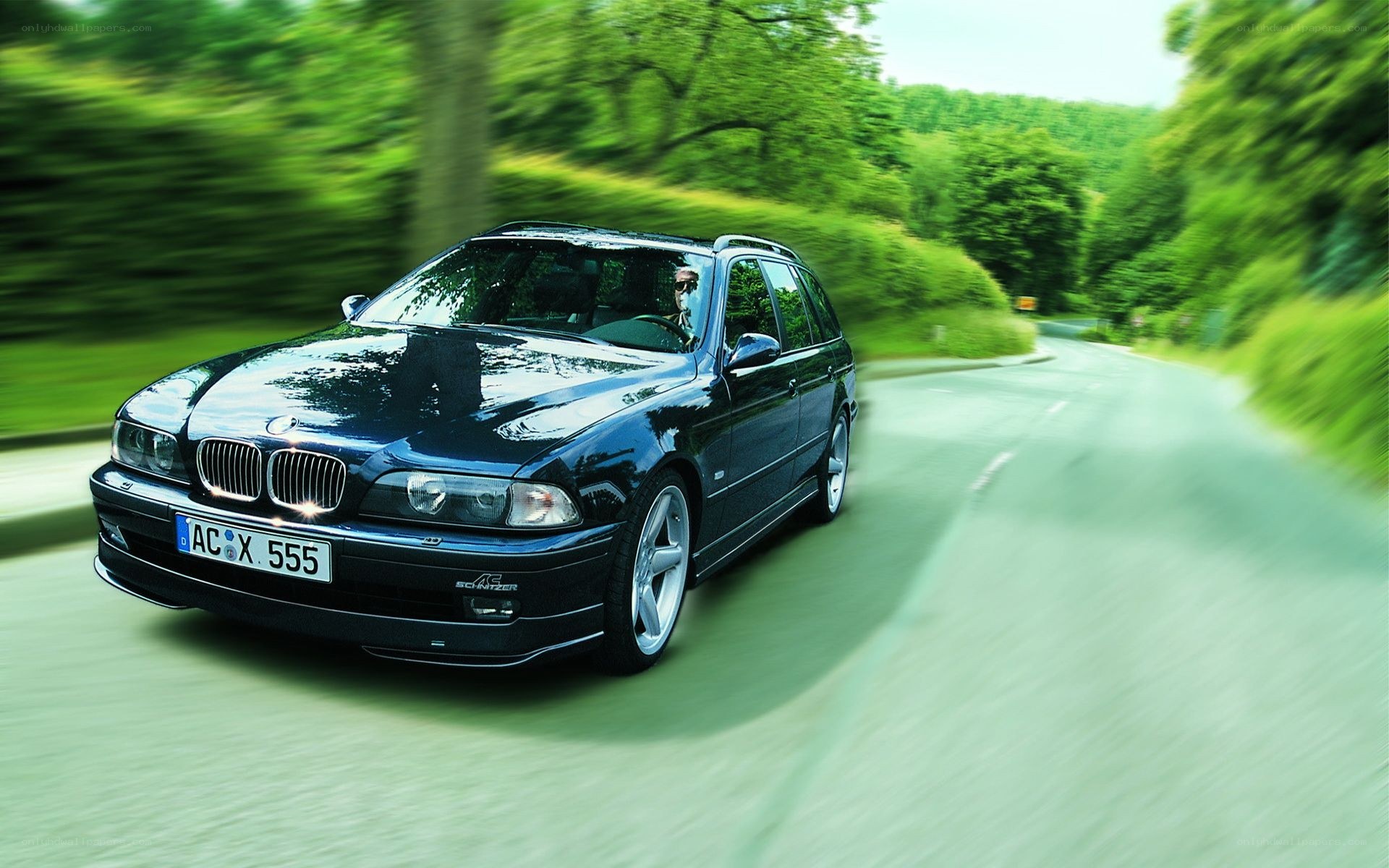 Black BMW driving on a road