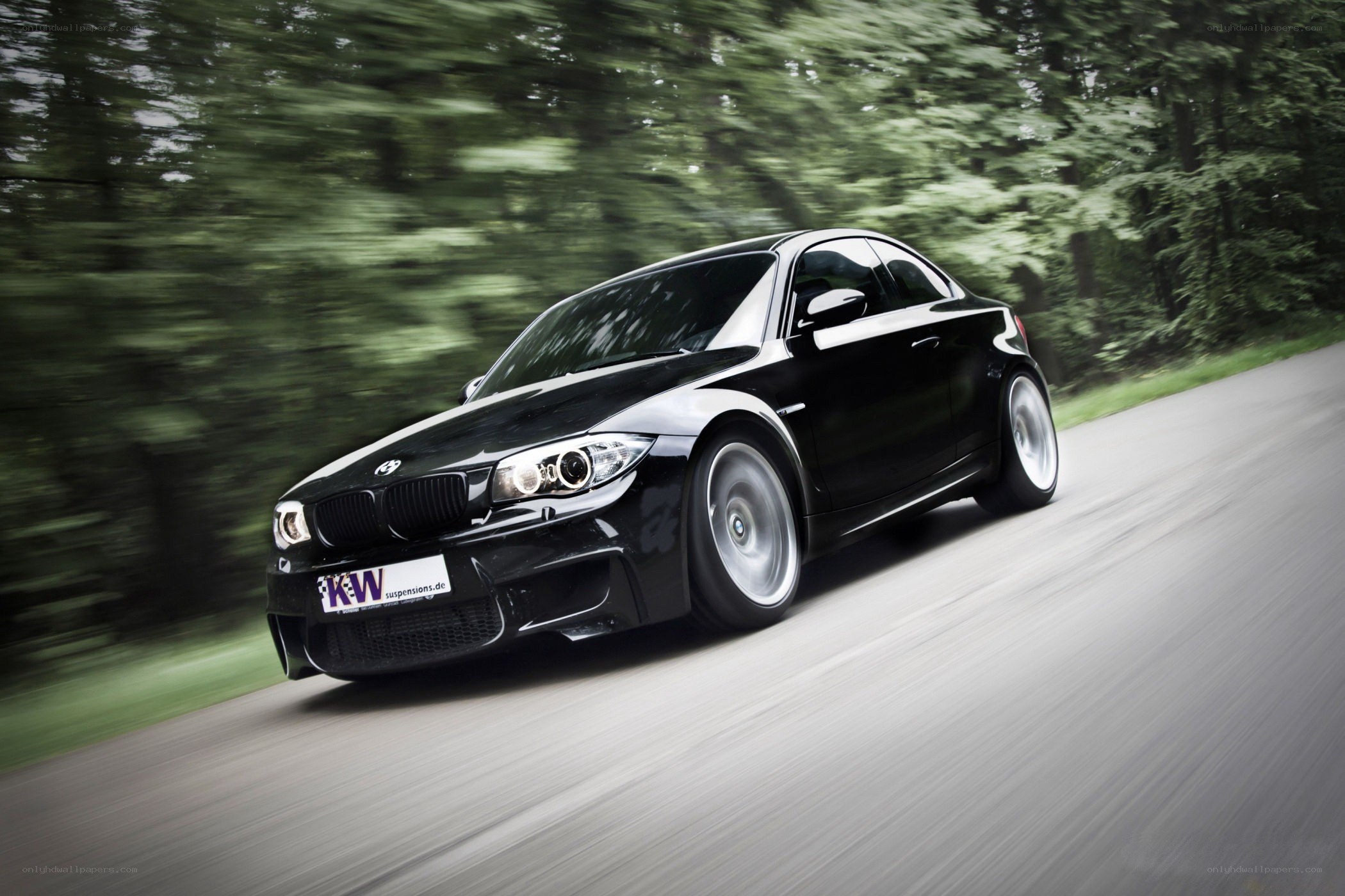 Black BMW driving on a road