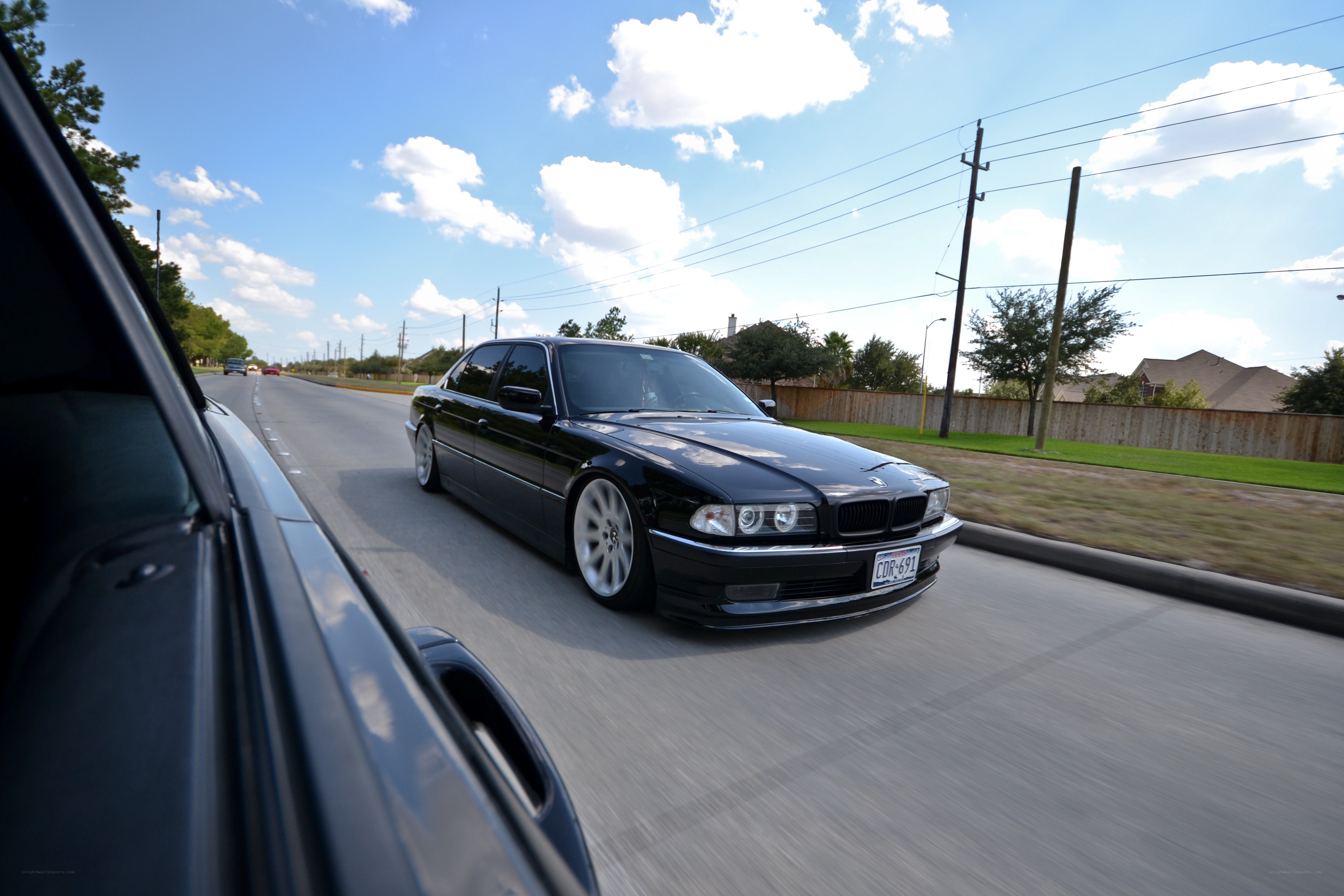 Black BMW driving on a road