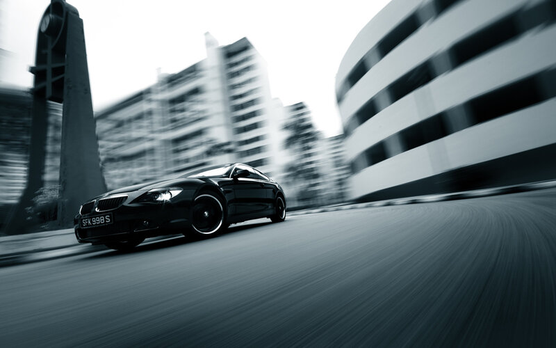 Black BMW driving on city street