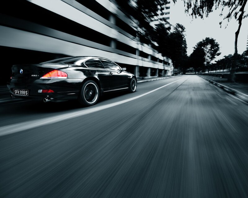 Black BMW driving on city street