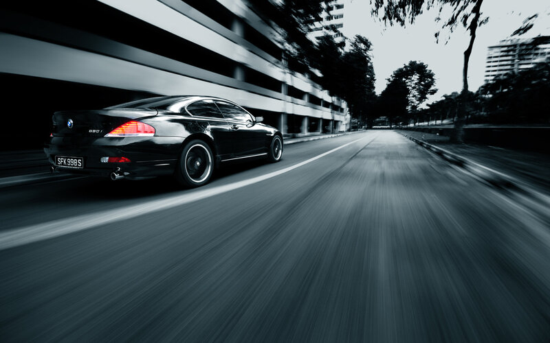 Black BMW driving on city street