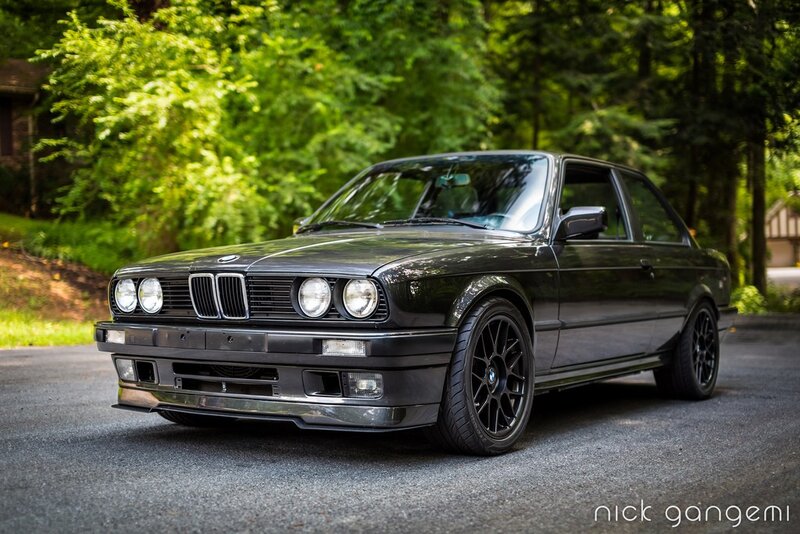 Black BMW E30 in a forest